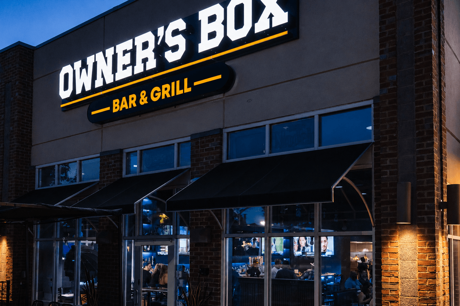 The Owner's Box storefront at night