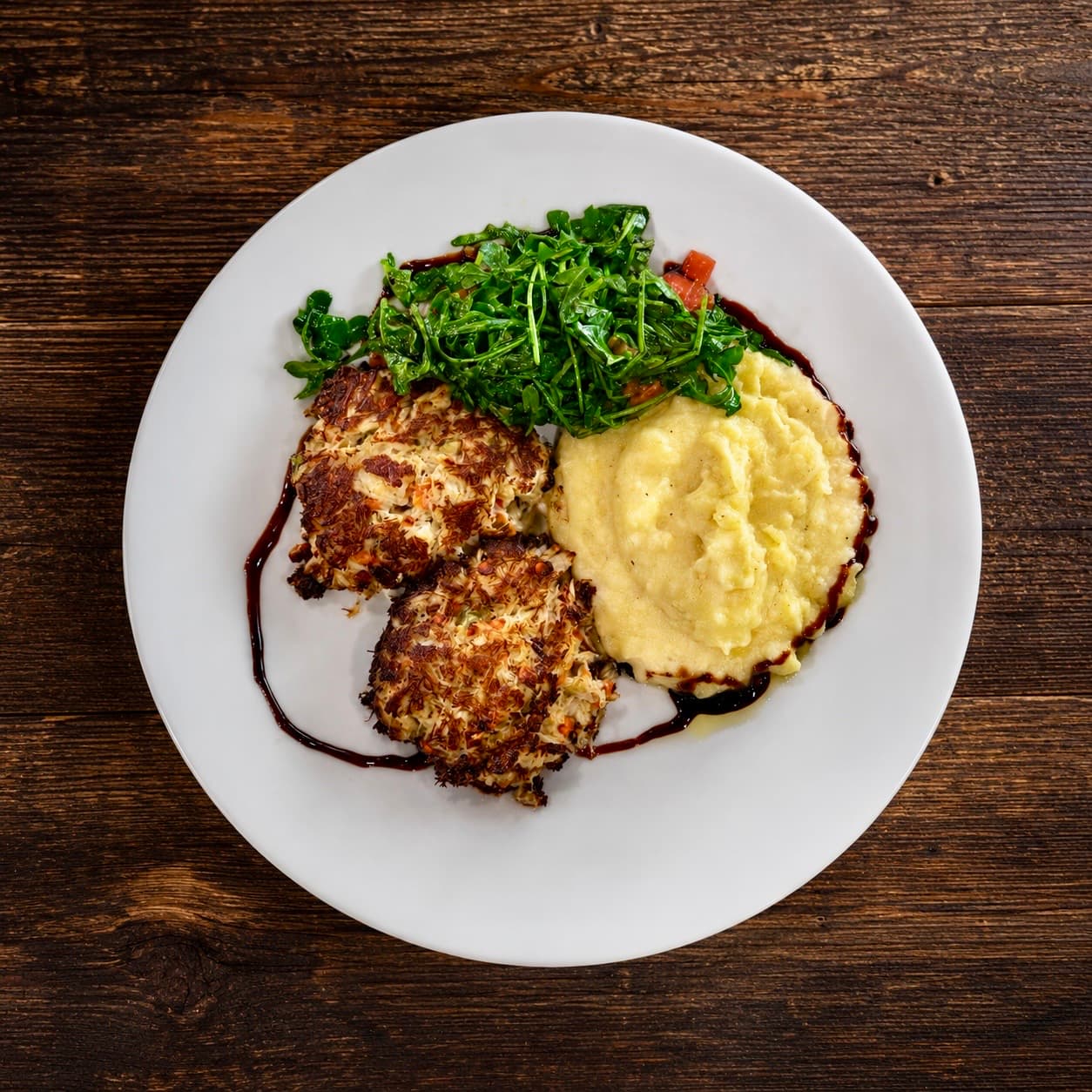 Crab cake platter with mashed potatoes and arugula