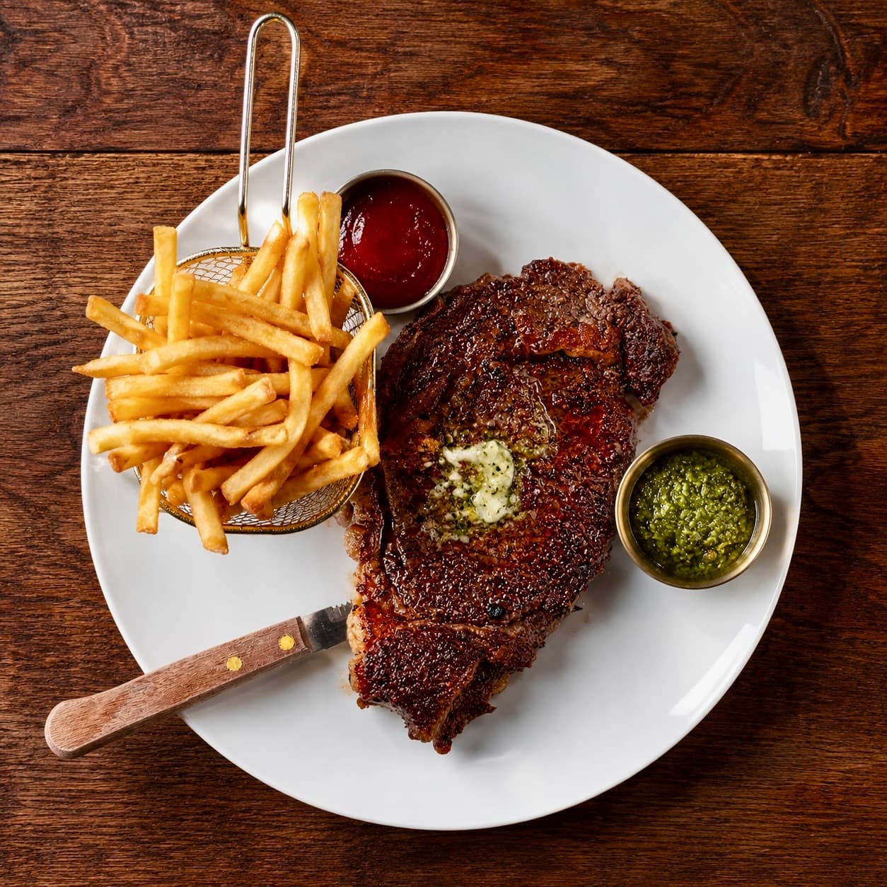 Rib eye steak with fries and chimichurri